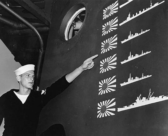 US sailor W.R. Martin points to scoreboard of light cruiser USS Boise from the Battle of Cape Esperance, 11-12 October 1942; the six Japanese ships claimed overstates actual enemy losses, not uncommon in night battles, Philadelphia Naval Shipyard, PA, November 1942 (US Naval History and Heritage Command).