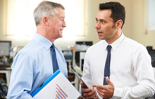 businessman having discussion with senior mentor in office