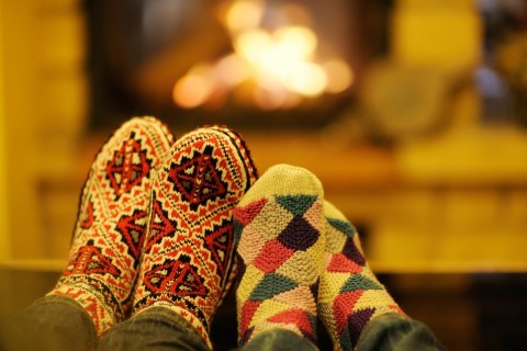 happy Young romantic couple sitting on sofa in front of fireplace at winter season in home