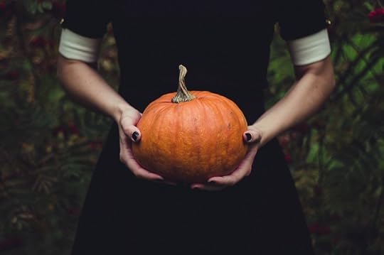 witch's hands holding a pumpkin