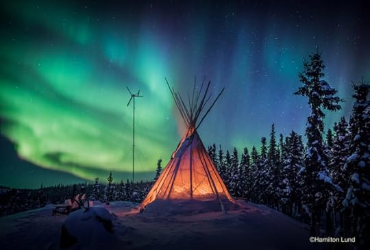 Emerald freeways dance above a tipi fire at Blachford Lake Lodge in Canada's North West Territories. By Hamilton Lund.