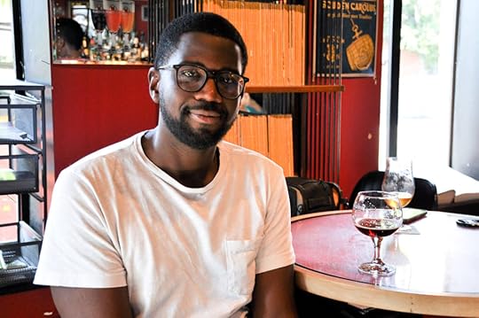 De'Mar Hamilton, the drummer for the Plain White T's, pictured sitting casually at a table beside a glass of whine. He's a black guy.