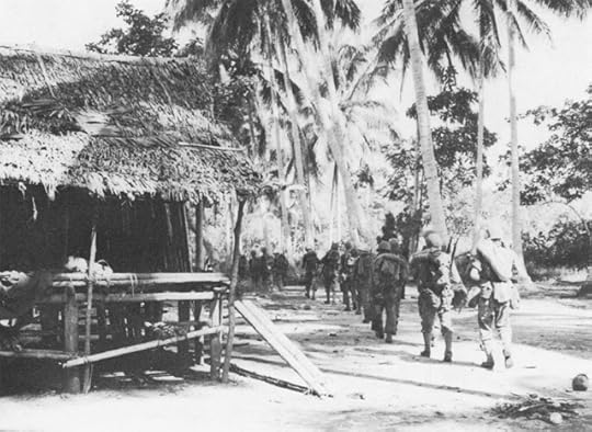 Troops of the US 128th Infantry Regiment passing through Simemi Village on way to Buna-Gona area, November 1942 (US Army Center of Military History)