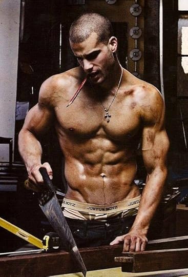 photo of shirtless man holding saw cutting boards