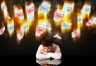 Depressed businessman sitting under falling papers