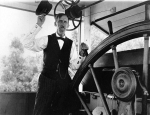 A pilot salutes in the pilothouse of the Str. Stacker Lee