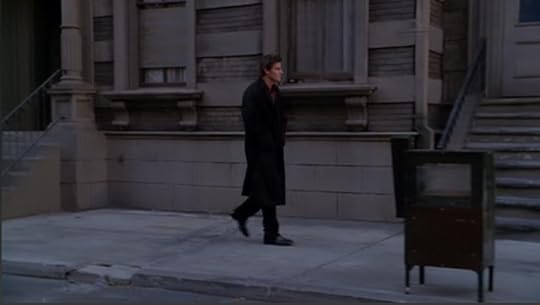 Angel, walking down a sidewalk in the early morning sun.