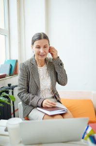 Woman listening with headphones with laptop in foreground