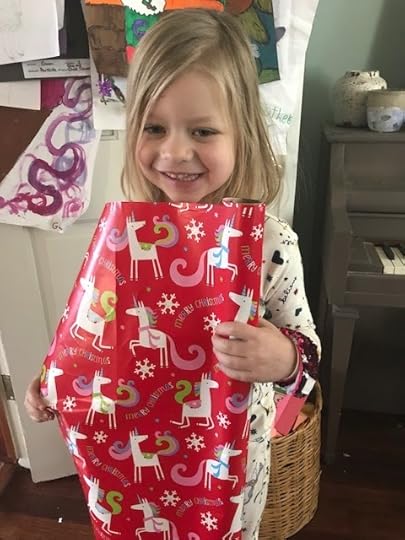 Poppy holding unicorn wrapping paper