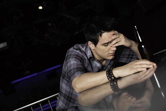 Man with alcohol in bar or club holding head because of confusion and headache.