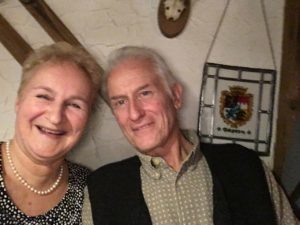 Woman and man in front of a wall smiling