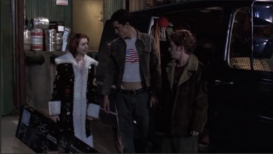 Willow, Devon, and Oz are standing next to Oz's van. Devon is wearing some kind of printed jacket over a t-shirt that's several sizes too small, revealing his abs and low-rise jeans.