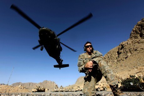 A U.S. Army soldier takes cover as a Black Hawk chopper takes off from a U.S. military base in Arghandab valley near Kandahar.