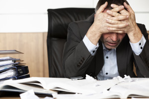 bigstock-Worried-businessman-sitting-at-19499636