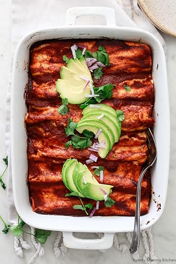 A beautiful pan of red enchiladas topped with sliced avocado, cilantro, and red onion. These delicious black bean enchiladas are vegetarian and vegan friendly.