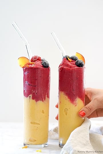 Beautiful peach smoothies topped with a pink raspberry layer in tall glasses. This easy vegan peach smoothie is so refreshing and delicious! It's perfect for breakfast or snack.