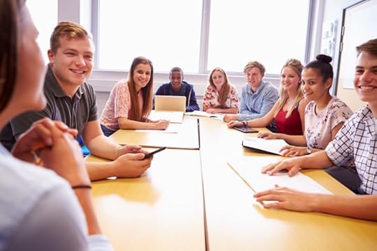 College Students Sitting At Table Having Discussion