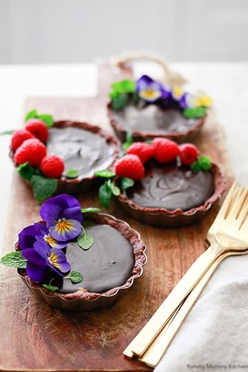 Beautiful chocolate tarts topped with edible flowers, raspberries, and mint leaves. These delicious tarts inspired by Hail Merry tarts are vegan, gluten free, and paleo friendly.