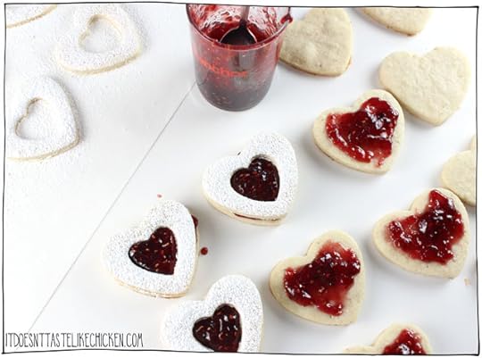 Vegan Linzer Heart Cookies! The buttery soft sugar cookie, sprinkled with powdered sugar, filled with sweet raspberry jam. They are every bit as tasty as they are adorable. Perfect for a gift for a loved one on Valentine's day or other special occasions. Egg-free, dairy-free. #itdoesnttastelikechicken #valentinesday #veganvalentines #veganbaking