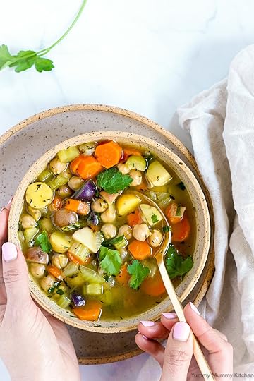 A colorful bowl of vegetable soup with carrots, celery, potatoes, and chickpeas topped with fresh parsley. This is the best vegetarian chicken soup recipe!