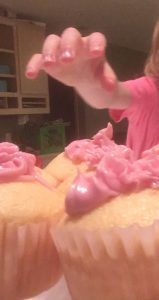 Hand reaching for pink cucpake