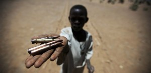 A child holds up bullets collected from the ground in Rounyn, a village about 15 kilometres from Shangel Tubaya, North Darfur. Most of the villages population has fled to camps for internally displaced because of heavy fighting between Government of Sudan and rebel forces.