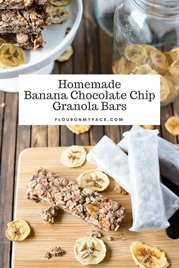 Homemade Banana Chocolate Chip Granola Bars wrapped in parchment paper on a wooden cutting board.