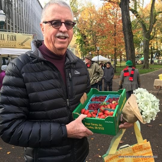 happy shopper with season's last strawberries at Portland Farmers Market in Portland, Oregon