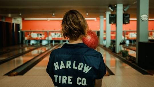 Girl holding bowling ball in a bowling alley.