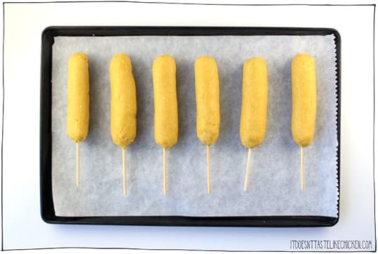 Baked Vegan Corn Dogs! A healthier version of this awesome fair food made at home. Crispy, flaky, lightly sweet, seasoned cornmeal crust is so tasty, it tastes like the best cornbread ever is wrapped around your veggie dog. Serve hot out of the oven with ketchup or mustard and oooeee are you in for a treat! #itdoesnttastelikechicken #veganrecipes #bakednotfried #snack