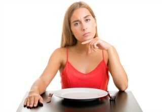 Hungry woman on a diet waiting with an empty place, isolated in white