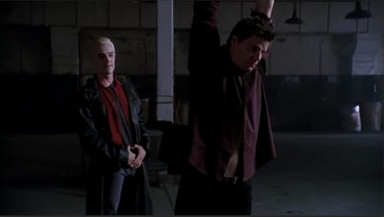 Angel is captured, suspended by his arms in the middle of a grim warehouse setting. Spike stands behind him, gloating.