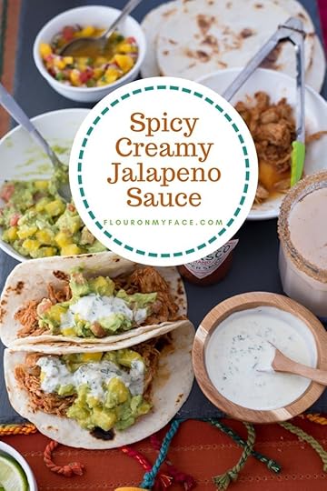 Creamy Jalapeno Sauce in a round wooden bowl served with chicken tacos, mango guacamole and homemade Horchata