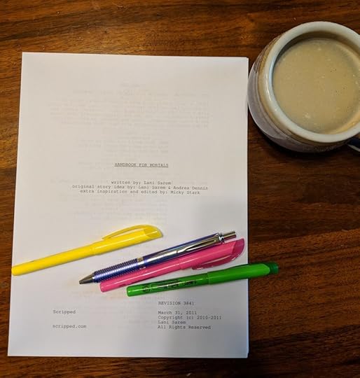 A photo of the Handbook For Mortals screenplay on my dining room table, with highlighters and a mug of coffee.