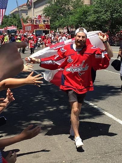 Philipp Grubauer, one the Capitals' goaltenders, hopped off one of the busses and ran a lap draped in the District of Columbia's flag, high-fiving fans.