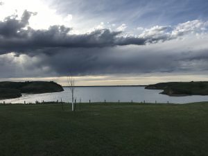 Lake Sakakawea in twilight, thunderclouds overhead, last light glimmering on the water
