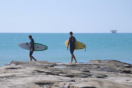 Surfers entering water at Piscinas Peru