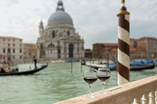 Two glasses of red wine on a railing in Venice