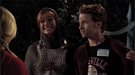 Oz pulling back his jacket to reveal a name tag that reads GOD, while Willow beams proudly at their joke.