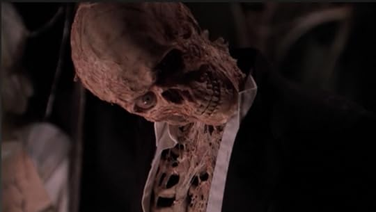It's a human skeleton now, covered in spiderwebs of sinew and rotting flesh, with one good eye that stares directly into the camera. Its head is tilted down in an oddly seductive way.
