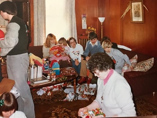  Christmas at Grandma’s. Grandma opening a present in the foreground. I’m with my mom in the background, sporting a Strawberry Shortcake dress and admiring my new See N Say.&nbsp; 