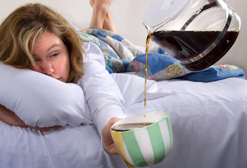 Bleary-eyed woman reaches out mug for coffee