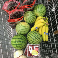 grocery cart full of watermelons, cherries, and bananas