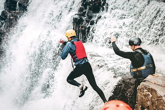 Coasteerers jumping off waterfall