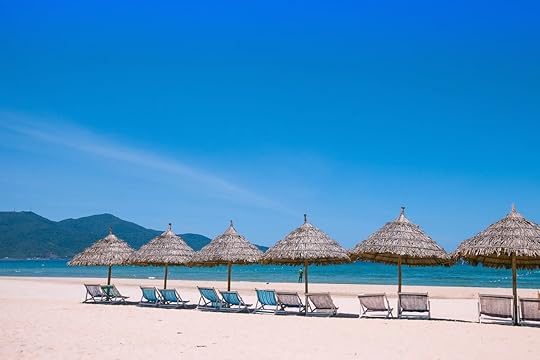 Beach umbrellas and deck chairs in front of the My Khe beach in Da Nang, Vietnam