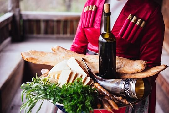 Woman holding tray of Georgian food and wine
