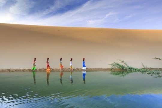 Women carrying water sand dunes