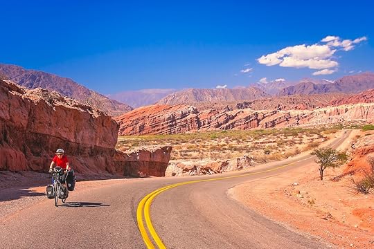 Woman cycling on the empty road to Cafayate in the remote part of north west Argentina