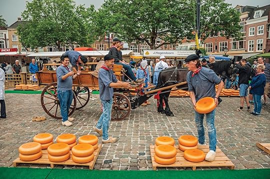 Young people carrying cart with cheese at the end of Market Square fair in Gouda, Netherlands