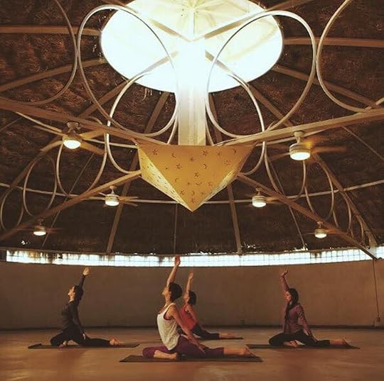 women doing yoga in a yurt under an artistic light fixture
